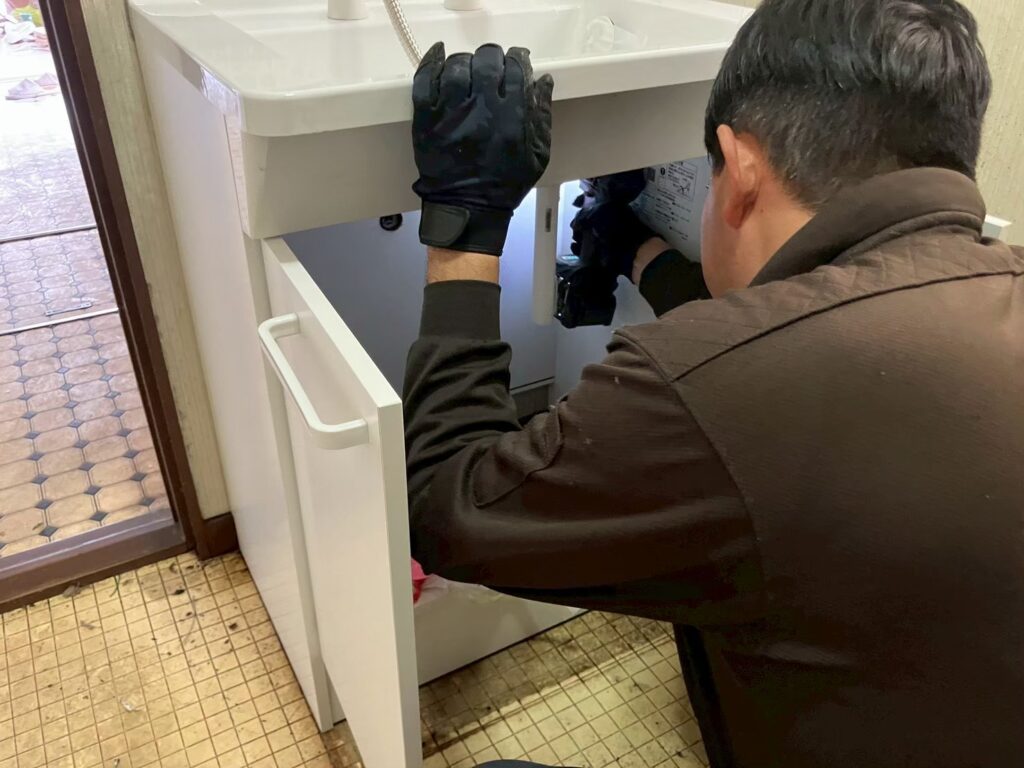 新しい洗面台の下台を取り付けている様子